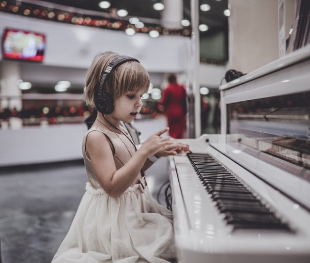 girl playing piano with headphones on