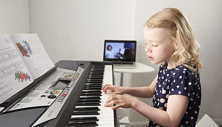 girl playing keyboard on video lesson