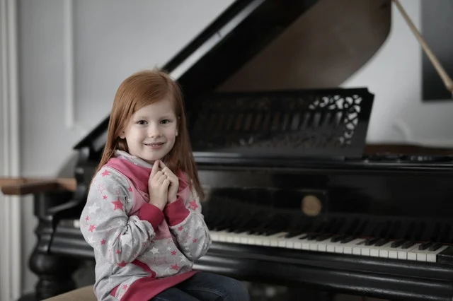 girl sat at piano