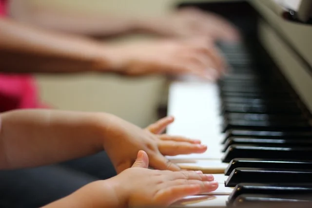 student playing piano with tutor